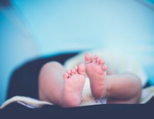 Baby wellness sessie: moeder geeft zachte babymassage aan pasgeboren baby in warme, rustige omgeving voor ontspanning